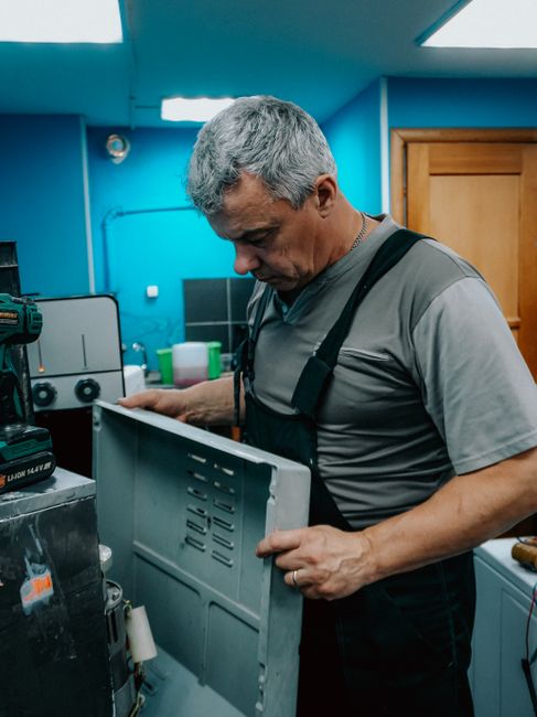 Technik opravuje práčku priamo v byte zákazníka